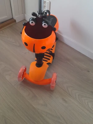 Orange sparkcykel med djurmotiv - Säljer en orange 3-i-1 sparkcykel från ScooTer med ett gulligt djurmotiv framtill. Sparkcykeln har tre hjul för extra stabilitet och ett handtag som går att justera. Perfekt för yngre barn som vill ha kul utomhus.
