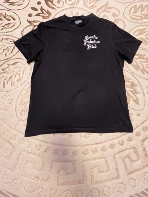 Svart Counter Productive Klub t-shirt - Svart t-shirt från Counter Productive Klub med vit tryckt text på bröstet och stor text på ryggen. Klassisk passform med rund hals och korta ärmar. Perfekt för dig som gillar streetwear och tydliga statement-plagg.