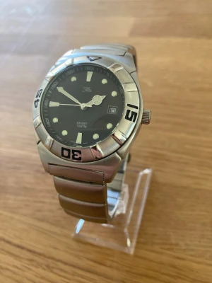 1990 Inex Sport Diver 42mm Herrklocka - Säljer en snygg stilren vintage herrklocka från danska Inex i till synes oanvänt skick. Plasten sitter kvar och inga repor enligt bilder. Fungerar utmärkt, originalarmband i rostfritt stål, datumvisare, mineralglas, japanskt urverk, vattentät, roterande dykarring, självlysande, osv. Behöver bara nytt batteri. Modell: CC1687.  Nypris: 1100-1700 SEK Begagnat värde: > 500 SEK (exkl. frakt) Mitt pris: 489 SEK  Skickas snabbt och spårbart. Skriv vid frågor och se gärna mina andra annonser!