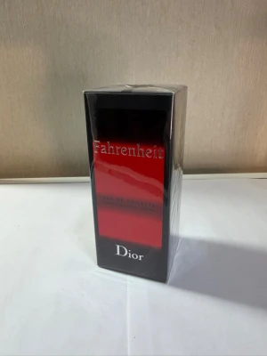 Dior Fahrenheit Eau de Toilette 100ml - Dior Fahrenheit Eau de Toilette i 100 ml flaska. Parfymen kommer i en snygg svart och röd kartong med silvrig text. Klassisk och ikonisk doft från Dior, perfekt för dig som gillar exklusiva och tidlösa parfymer.