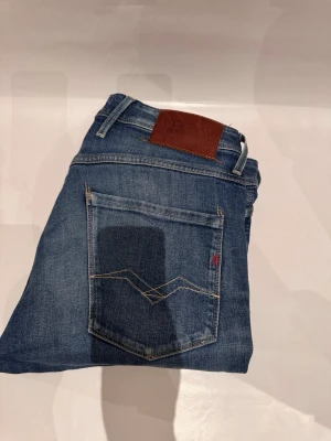 Replay Jeans - Jeans från Replay i snygg blå med en klassisk tvätt.. Skön passform som sitter perfekt.  Använda men skicket är väldigt bra. Nå smått slitage finns, men det smälter in och ser normalt ut (en liten skråma på insida häl men inget som syns eller tänks på vid användning). PRISET ÄR INTE FAST I STEN