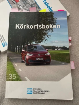 Körkortsboken + Studiehäftet STR - Säljer Körkortsboken och tillhörande Studiehäftet från STR. Båda böckerna har färgstarka omslag med en röd Volkswagen på landsväg och tydliga titlar. Perfekt för dig som pluggar till körkort och vill ha komplett material. Säljer körkortsboken från 2022, ett studiehäfte från samma år och vägmärken, samt lättläst version från 2018 samt ett studie häfte från 2019