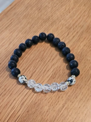 Armband med svarta och vita pärlor - Snyggt armband med lavasten, Bergskristall och dalmatinerjaspis trädd på elastisk tråd och passar perfekt för att ge din stil en cool touch. Det levereras i en söt liten påse tillsammans med information om kristallernas magiska egenskaper. Det är helt nytt och ett av mina egna skapelser. 