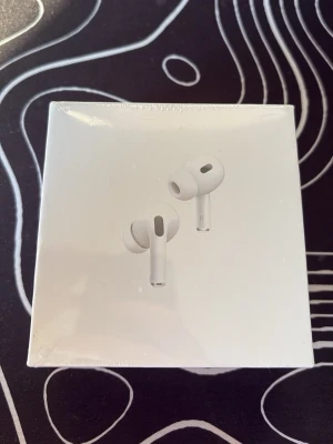 Apple AirPods Pro 2nd Gen - Säljer ett par vita Apple AirPods Pro (2nd generation) med stilren design och silikonproppar för bästa passform. Trådlösa in-ear hörlurar med brusreducering och laddningsetui. Perfekta för musik, samtal och gaming.