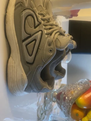 Gråa sneakers från CD - Snygga grå sneakers från CD med svart och vit logga på sidan och hälen. Skorna har en chunky sula och är gjorda i mesh och syntetmaterial för en sportig vibe. Perfekta för dig som gillar streetstyle och bekväma skor.Skorna kommer komma ny tvättade om du köper skorna har också en liten defekt men märker inte det
