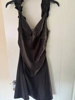 Svart satin klänning från Adoore - Supersnygg svart klänning från Adoore i glansigt satinmaterial. 