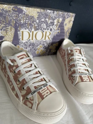 Dior sneakers rosa - storlek 38 - Säljer dessa snygga Dior sneakers i storlek 38. Skorna är i nytt skick och väldigt sparsamt använda. Elegant rosa/vit design med klassiskt Dior-mönster och originalkartong medföljer.  Perfekta för dig som vill ha en lyxig och stilren sneaker som passar till allt 🤍  📏 Storlek: 38 📦 Originalbox medföljer ✨ Skick: Som nya  Skriv vid intresse eller för fler bilder 😊
