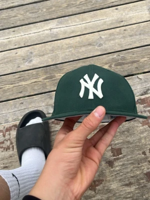 New era keps  - Säljer en par snygga gröna keps som jag hadde för några minuter och den mörka fläcken de är inte en fläck de e min vän som sprayade dio på den!