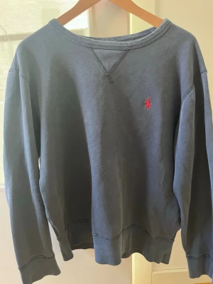Ralph lauren tröja - Blå sweatshirt från Ralph Lauren Polo i stl M, normal i storleken. Bomullstyg med rund hals, ribbade muddar och liten röd logga på bröstet. Kan gå ner i pris 
