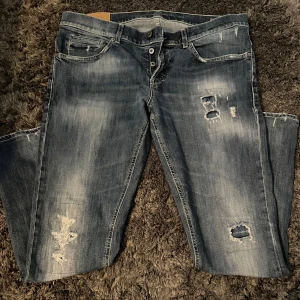 Dondup George Jeans  - Säljer nu mina as sköna dondup George jeans. Jeansen har en smalare passform med snygg tvätt och distressed look. Passar bra för personer som är runt 182 cm. Tveka inte att höra av er angående pris eller bilder! Finns ett hål vid skrevet.