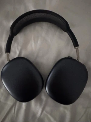 Svarta Apple AirPods Max hörlurar - Snygga svarta Apple AirPods Max over-ear hörlurar med mjuka öronkuddar och justerbart huvudband i mesh. Tillverkade i aluminium och rostfritt stål för en premiumkänsla. Perfekta för musik, gaming eller film med grym ljudkvalitet och modern design. Box finns med + kvittot. 