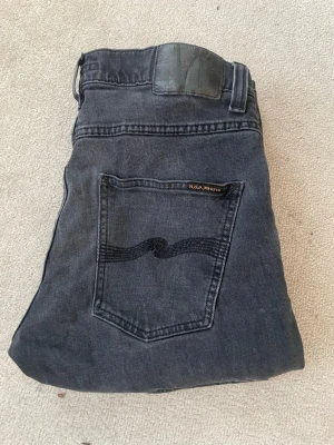 Nudie jeans grim tim - Snygga gråa jeans från nudie. Modellen är grim tim. Stl W31 L34