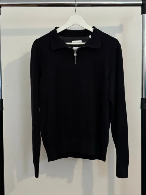 Svart  tröja med half zip från These Glory Days - Svart stickad tröja från These Glory Days med krage och half zip-dragkedja framtill. Använt några gånger så den är i bra skick.