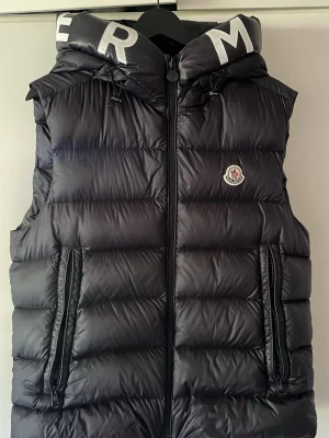 Moncler väst med huva - Moncler väst med huva i princip oanvänd (Använd 2 - 3 gånger) (Köpt i Palma de Mallorca) (Kvitto finns)                                                             Ny pris 12,000kr 