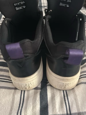 Eytys  - Snygga svarta sneakers med lila hälflik och vit sula. Skorna har klassisk snörning och perforerade detaljer på tån. Tillverkade i läderliknande material och har en chunky sula för extra stilpoäng.