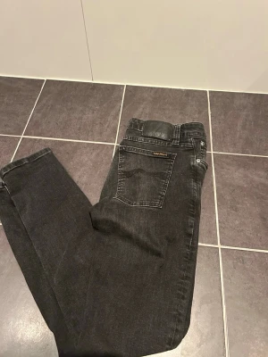 Svarta Nudie jeans  - Säljer ett par riktigt snygga Nudie jeans i str 30/30. Perfekt för dig som vill vara extra snygg inför sommaren.    Hör av dig vid minds fundering!