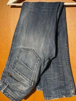 Diesel jeans - Märke: Diesel | Modell: Darron | Passform: Slim-Tapered | Storlek: 31/32 | Färg: Ljusblå tvätt | Skick 7/10 | Defekter: Hål och heeldrag (dock väldigt karaktärsgivande). Kom gärna med frågor!
