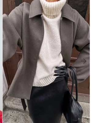 Slutsåld polotröja - Vit stickad polotröja med hög krage och avslappnad passform. Tröjan har ribbstickade muddar vid ärmslut och nederkant. Perfekt för lager-på-lager och ger en clean look till din outfit. Aldrig andvänt prislappen är kvar