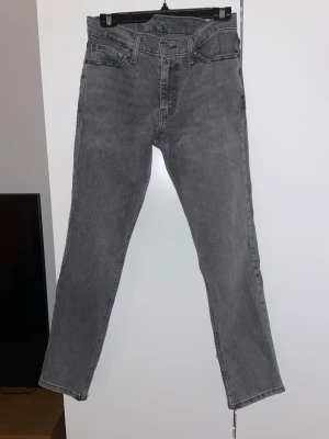 Grå Levi's 511 jeans  - Säljer ett par klassiska grå Levi's 511 som passar perfekt med en vit skjorta! Väldigt prisvärda och knappt använda vilket är ännu bättre! Bra kvalitet, utan defekter! Hör av dig för fler bilder!