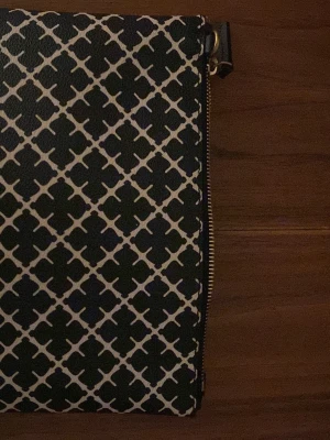 Svartvit kuvertväska från By Malene Birger - Snygg kuvertväska från By Malene Birger i svart och vitt med klassiskt grafiskt mönster. Väskan har guldfärgad dragkedja och är tillverkad i ett tåligt syntetmaterial. Perfekt för att lyfta vilken outfit som helst.