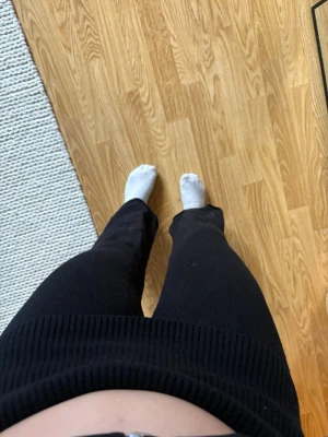 Svarta mjukisbyxor från Gina Tricot - Säljer ett par svarta mjukisbyxor från Gina Tricot med bred resår i midjan och raka ben. Byxorna är stickade och har en skön, mjuk känsla som passar perfekt för chill dagar hemma. Klassisk och enkel design som är lätt att matcha.