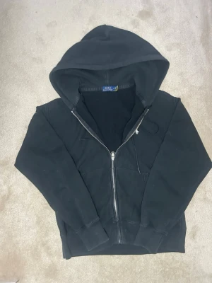 Äkta Ralph Lauren hoodie - Riktigt fet Ralph Lauren hoodie⚫️⚫️ storlek M😙. Självklart äkta.😇🙌🏼 Mått: axel bredd: 40cm. Längd: 60cm😆 Mycket bra skick, inga hål. Skickas endast med PostNord📦➡️ Skickas inom 24 timmar efter köp.🤩 För frågor och funderingar är aktiv🙌🏼🙏