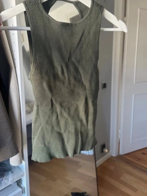 Zara topp - Säljer en olivgrön ärmlös linnetopp med ribbad struktur upptill och slät nedtill. Aldrig använt, från Zara utsåld. Kom gärna om du har frågor 💞