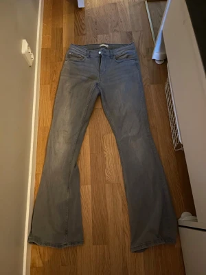 Grå bootcut jeans från Gina Tricot - Snygga grå jeans från Gina Tricot i modellen Perfect Jeans. Byxorna har bootcut-ben, klassiska fem fickor och normal passform. Tillverkade i mjukt jeanstyg som sitter skönt på kroppen. Perfekta till sneakers eller boots.