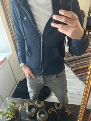 Ralph Lauren Zip Hoodie - Snygg marinblå zip hoodie från Ralph Lauren. Aldrig använd, endast provad. Storlek M men passar S då den är liten i storleken. Klassisk design med vit logga. Fleecematerial inuti som är superskönt. Helt i nyskick. Nypris: 2400kr Hör gärna av er vid funderingar och lägg bud!💕