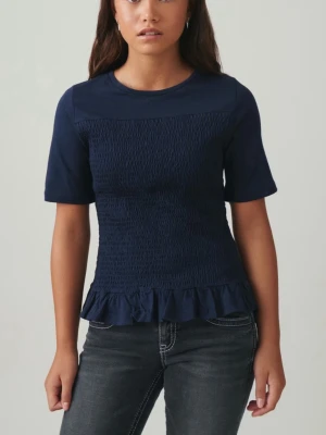 Marinblå smockad topp med volang - Säljer en marinblå topp från Gina  med smockad midja och volangkant nedtill. Toppen har korta ärmar och rund halsringning, tillverkad i mjuk bomull. Aldrig använd för den är för stor 