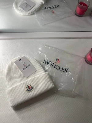 Vit ribbstickad mössa - Snygg vit ribbstickad mössa med uppvikt kant och klassisk framtill. Tillverkad i mjukt material som håller dig varm och stilren. Perfekt accessoar för kyliga dagar och enkel att matcha med olika outfits.