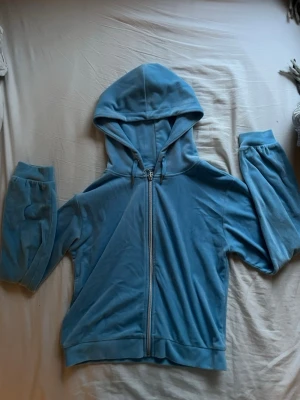 Ljusblå velourhoodie med dragkedja - Mysig ljusblå hoodie i mjuk velour med dragkedja framtill och huva. Perfekt för en avslappnad och trendig look. Ganska tidigt 2000 tal vibes. Den är också super bekväm!