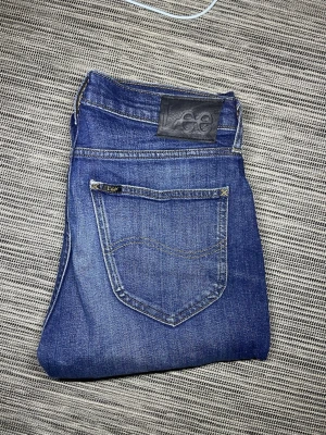 Blå jeans från Lee - Snygga blå jeans från Lee i klassisk modell och fem fickor. Jeansen har Lee-logga på bakfickan och bak i midjan. Tillverkade i slitstarkt denimtyg med snygg tvätt och kontrastsömmar. Perfekta för en stilig och trendig look.