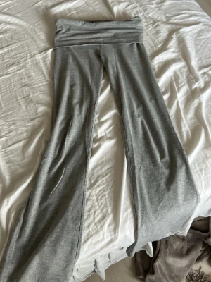 Grå mjukisbyxor från Gina Tricot - Säljer ett par grå mjukisbyxor från Gina Tricot med bred linning och utsvängda ben. Byxorna är gjorda i mjukt och stretchigt material, perfekta för chill dagar. Klassisk modell som är enkel att matcha med hoodies eller t-shirts.