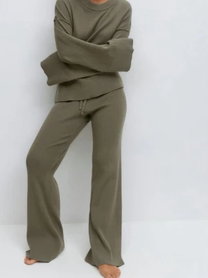 Olivgröna ribbade mjukisbyxor - Slutsålda - Endast provade! Mysiga loungebyxor i olivgrönt ribbat material med breda ben och dragsko i midjan. Perfekta för chill dagar hemma. Byxorna har en avslappnad passform och är tillverkade i mjuk trikå som känns skön mot huden.