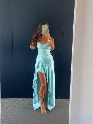 turkos/ljusblå bal klänning 🩵 - Supersnygg ljusblå långklänning i satin med  slits och öppen rygg med snörning. Klänningen har smala axelband och en elegant, figurnära passform. Använd bara en gång vid bal. Snörningen gör att den är hyfsat justerbar. Jag är 158 och den är lång på mig men hade höga klackar 