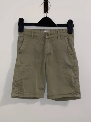 Beige bomullsshorts med fickor - Snygga beige shorts i bomull med klassisk passform. Shortsen har framfickor, bakfickor och bälteshällor. Perfekta för varma dagar och enkel att matcha med olika stilar. Mått: bredden är ca 28cm och längden är ca 36cm 