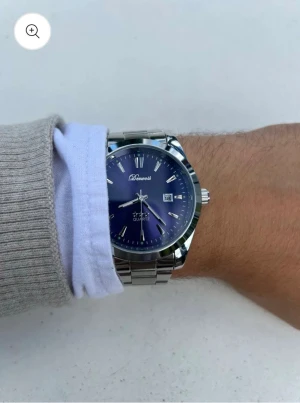 Silverfärgad klocka med blå urtavla från Doventi  - Stilren klocka med metallarmband och blå urtavla från Doventi . Klockan har tydliga markeringar, datumvisning och klassisk rund form. Perfekt accessoar för dig som gillar en clean och modern look.