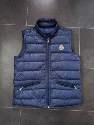 Moncler väst - Mörkblå väst från Moncler. Storlek XS. 2016 modell. Sjävklart äkta. Köptes för 3000 och säljer för att den är för liten. Ställ annars frågor!