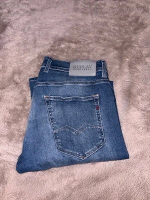 Blå jeans från Replay - Snygga blå jeans från Replay med klassisk femficksdesign och ljus tvätt. Jeansen har raka ben och tydliga sömmar på bakfickan. W34  L32 Ny pris 1800 kr 