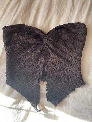 Brun bandeau tubtopp från SHEIN - Säljer en brun bandeau tubtopp från SHEIN i storlek M. Toppen har en ribbad struktur och knytband framtill som ger en snygg detalj. Perfekt för dig som vill ha en trendig och unik topp till sommaren.