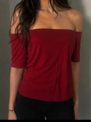 Mörkröd offshoulder topp strl XL motsvarar strl L  - Trendig mörkröd offshoulder topp med halvlånga ärmar. Snygg  passform som sitter tight över axlarna och ger en clean look. Perfekt att styla med höga jeans eller kjol. Liten XL mer som strl L 