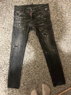 Svarta Dsquared2 Jeans - Ett par svarta Dsquared2 Jeans (Självklart äkta) i storlek 50. Dom har ett par lagningar på insidan vilket är anledningen till det så billiga priset och för att jag vill göra mig av med dom pågrund av att dom inte kommer till användning. om du har frågor så är det bara att ställa dom.