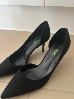 Svarta  pumps  - Snygga svarta pumps från Elisaman med spetsig tå och smal klack. Skorna har en klassisk siluett och är tillverkade i ett material som ser ut som mocka. Perfekta för dig som vill ha en elegant och stilren look. Helt nya passade inte mig i storlek.