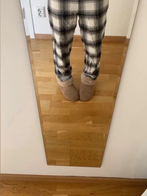 Rutiga pyjamasbyxor i vit och svart - Mysiga pyjamasbyxor med rutigt mönster i svart och vitt. Byxorna har en avslappnad passform och är perfekta för hemmakvällar. Tillverkade i mjukt material som känns skönt mot huden.                                                         lappen är bortklippt men jag skulle säga att det är runt storleken 146/152 och som referens är jag runt 158 cm❤️ de är använda men ändå i fint skick!! 