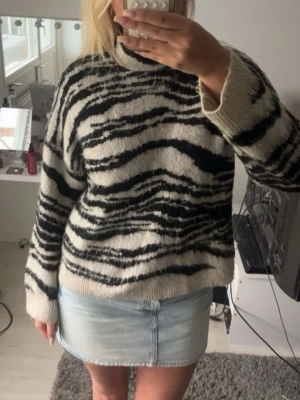 Stickad zebra tröja - Snygg stickad zebra tröja med halvpolo krage. Storlek L passar även M.
