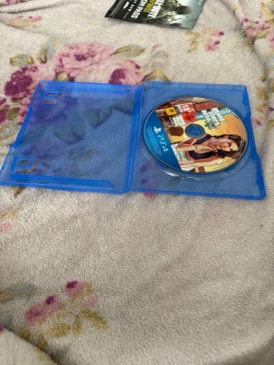 Grand Theft Auto V  - Säljer Grand Theft Auto V till PlayStation 4. Spelet kommer i ett blått plastfodral och skivan har färgstark grafik med spelets logga och en karaktär på framsidan. Perfekt för dig som gillar action, äventyr och öppna världar.