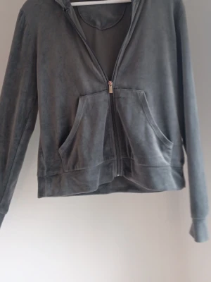 Mjuk grå matchand set velourhoodie Gina Tricot - Säljer en grå velourhoodie och matchande bootcut mysbyxor från Gina Tricot med dragkedja framtill och två stora fickor. Hoodien har huva och långa ärmar, perfekt för en avslappnad och trendig look. Materialet är mjukt och skönt mot huden💕