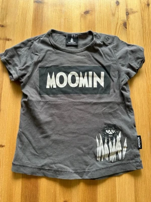 T-shirt  - T-shirt för barn med Moomin tema och knappar vid ena axeln för att lättare ta av och sätta på