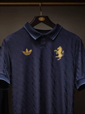 Juventus 2024/2025 Mörkblå  - Mörkblå pikétröja från Adidas i samarbete med Juventus. Tröjan har diskret mönster i tyget, guldfärgade Adidas-logga och Juventus-emblem på bröstet samt guldfärgad 'JUVENTUS' text i nacken. Klassisk krage och korta ärmar. Perfekt för fotbollsfans.